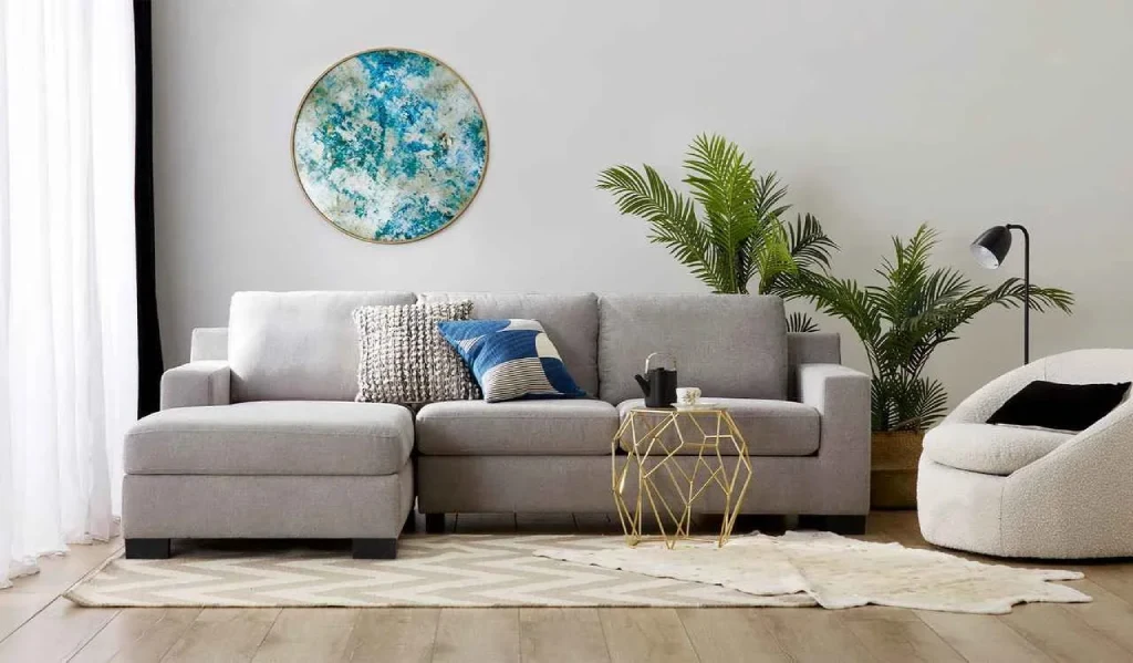 A modern living room featuring a grey sectional sofa with a chaise lounge