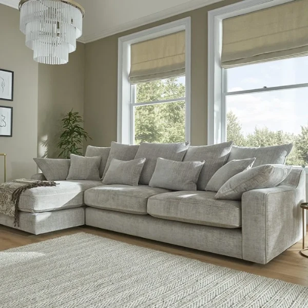 A spacious living room with a large, grey fabric sectional sofa featuring a chaise lounge.